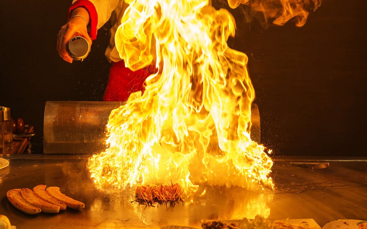 Private hibachi chef cooking with flames on a backyard grill for a Vaughan bridal shower party celebration
