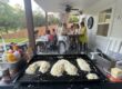 Private hibachi chef's grill under a covered backyard patio with fried rice shaped into a heart and party guests at tables, a setup idea for a Hamilton Halloween hibachi party