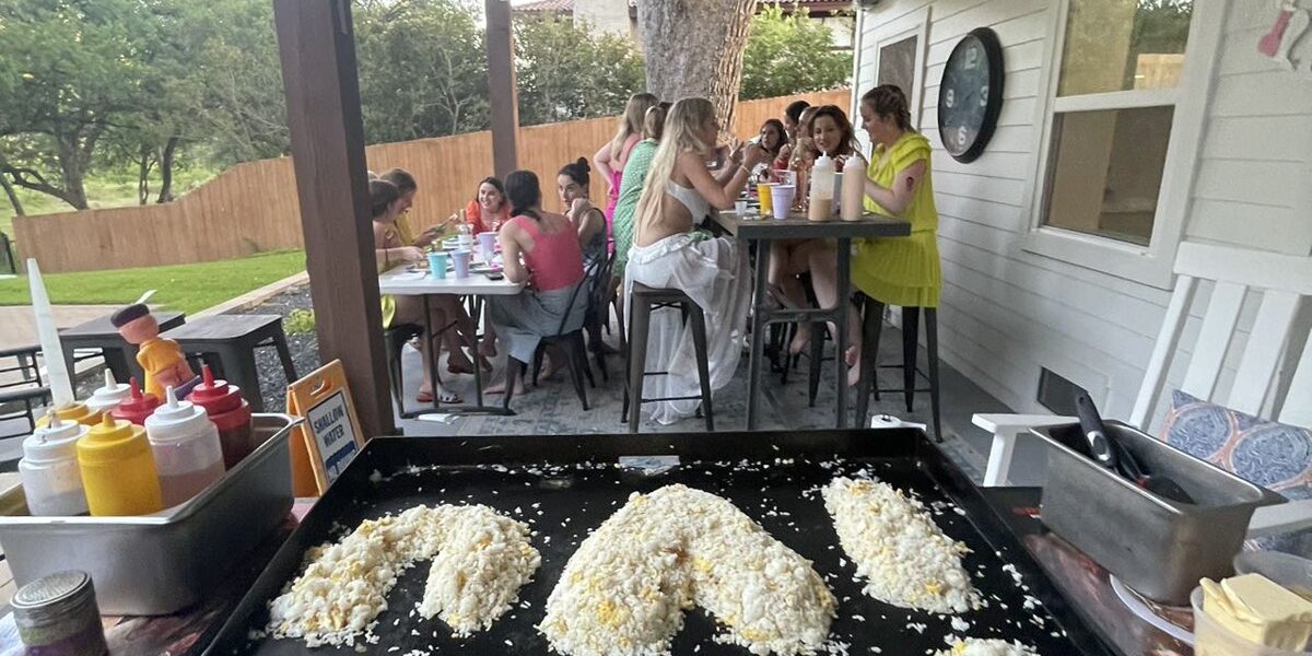 Private hibachi chef's grill under a covered backyard patio with fried rice shaped into a heart and party guests at tables, a setup idea for a Hamilton Halloween hibachi party